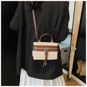 Detailed back view of a beige canvas box bag with brown leather trim and top handle