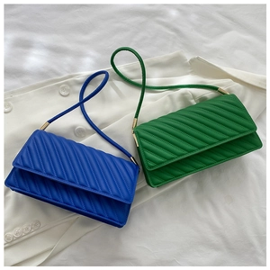 Détail de petits sacs carrés colorés avec coutures texturées et détails en métal doré