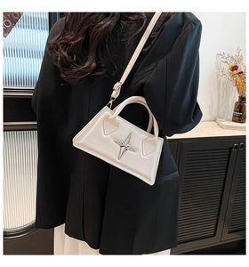 Détail du petit sac blanc en cuir avec étoile métallique argentée et poignée chic