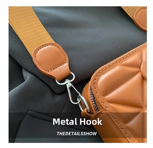 Close-up of premium silver metal hardware hook on brown quilted luxury crossbody bag
