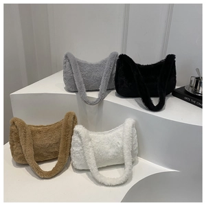 Plush shoulder bags in grey, black, khaki, and white on minimalist display stands
