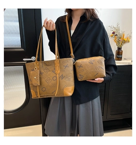 Detail of caramel tote bag set featuring monogram pattern and crossbody clutch bag