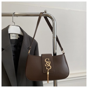 Close-up of a dark brown crescent bag with a gold SS letter logo and stylish fringe tassel
