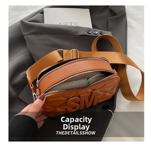 Detail view of caramel brown quilted crossbody bag showing dual zipper and spacious interior