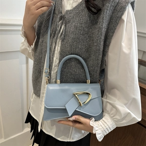 Borsa chic in finta pelle azzurra con taglio asimmetrico e fibbia a D dorata