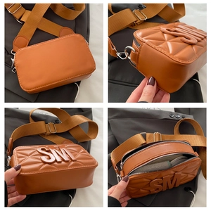 Detail view of orange camera bag with embossed texture, wide strap, and interior space