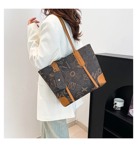 Detail of large vintage tote bag with letter print and contrasting leather trim