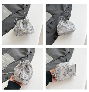 Détails du sac seau en jacquard argenté avec broderie florale et breloques en perles