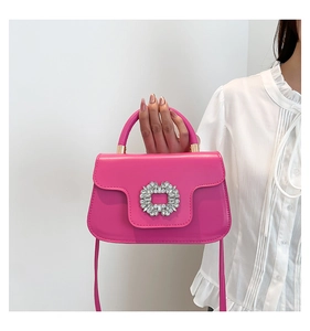 Gros plan sur le sac en cuir fuchsia avec une boucle florale ornée de cristaux