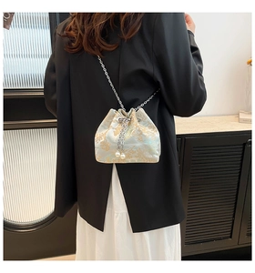 Détail du sac seau en soie brodée avec bandoulière chaîne argentée et perles déco