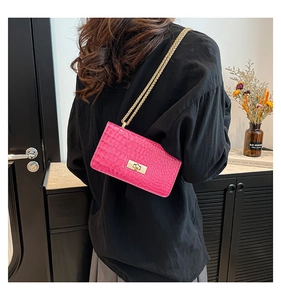 Détail du sac à main rose gaufré crocodile avec chaîne dorée et fermoir en métal