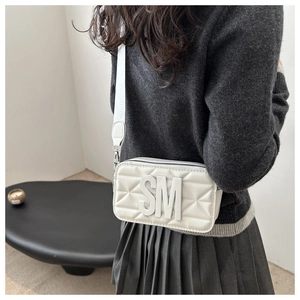 White quilted camera bag with bold SM 3D letters and a wide detachable shoulder strap