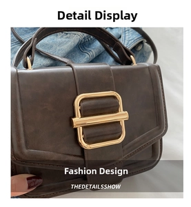 Detail view of deep brown vintage textured faux leather bag with large gold square buckle
