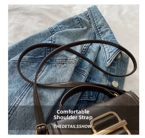 Close-up of slim brown leather strap and gold rectangular buckle on crossbody bag