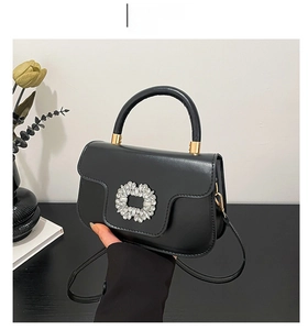 Vue détaillée du sac à main noir avec boucle en strass étincelants et finitions dorées