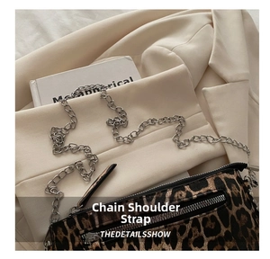 Detail of leopard print crossbody bag with silver chain strap and front zipper pocket