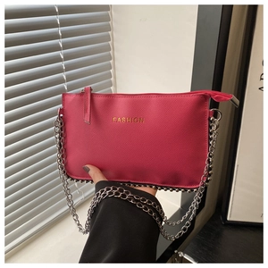 Detail of rose pink lychee textured crossbody bag with gold FASHION text and chain strap