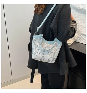 Detail of light blue silk embroidery handbag with leather handle and shoulder strap