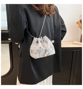 Détail d'un sac seau en soie à motif jacquard vintage et cordon de perles élégant