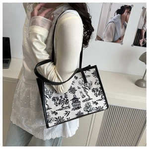 Dettaglio della borsa tote in tela con finiture in pelle nera e stampa paesaggio