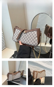 Close-up of brown patchwork baguette bag with floral metal clasp and canvas print