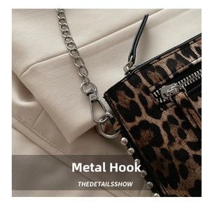 Detail shot of leopard print bag texture with silver metal chain and lobster clasp