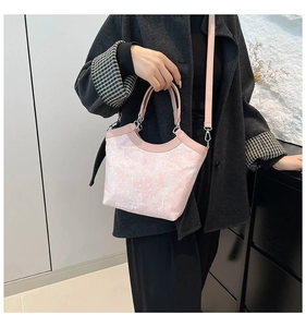 Detail view of pink floral jacquard handbag with leather handle and silver metal hardware