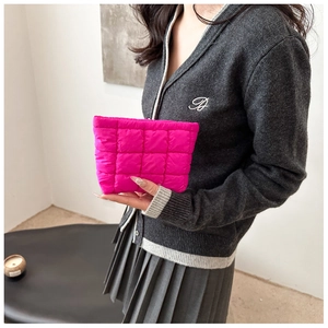 Hot pink padded quilted cosmetic bag held by a model for a trendy fashion look