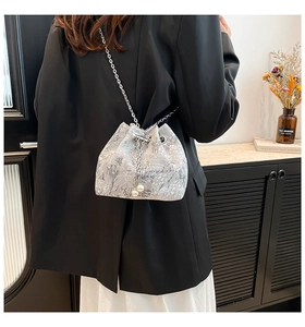 Détail du sac seau en jacquard argenté avec tissage floral, chaîne et perles décoratives