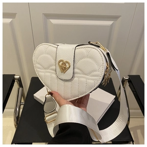 Detail of heart-shaped crossbody bag with quilted leather and golden twist lock