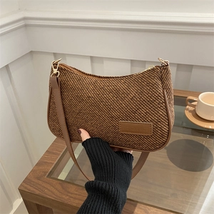 Minimalist brown woven crescent crossbody bag with adjustable strap and metallic lock