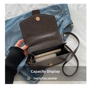 Detail showing inner capacity of dark brown leather crossbody bag with magnetic buckle
