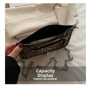 Macro view of leopard print crossbody bag showing interior phone compartment and zipper pocket