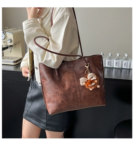 Détail du grand sac cabas marron foncé vintage avec texture cuir et pendentif peluche