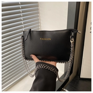 Detail of black pebbled leather crossbody bag with silver rivets and fashion logo