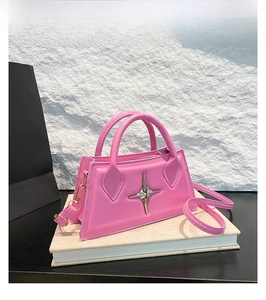 Dettaglio borsa a tracolla in ecopelle rosa con stella in metallo argentato su libro