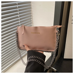 Detailed view of pink crossbody bag with silver rivet base and golden fashion lettering