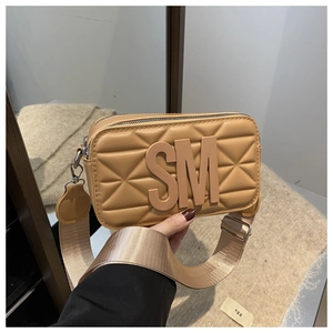 Close-up of khaki quilted camera bag with SM logo and stylish wide woven shoulder strap