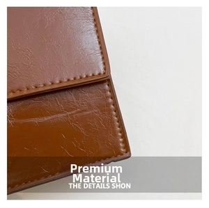 Close-up of brown vintage oil-wax leather texture with precise stitching detail on the bag