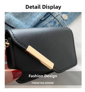 Dettaglio della borsa in pelle nera con finiture in metallo dorato su sfondo denim
