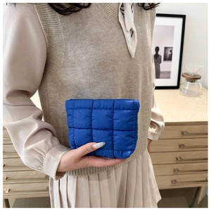 Close-up of klein blue quilted makeup bag featuring square padded texture and nylon fabric
