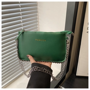 Detail of green leather handbag with gold FASHION lettering and silver chain strap