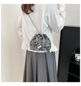 Détail du sac seau floral avec cordon à perles et bandoulière en chaîne métallique
