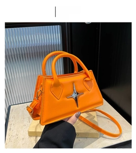 Dettaglio della borsa a trapezio arancione con decorazione a stella in metallo argento