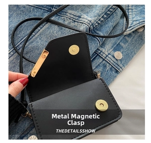 Dettaglio della chiusura magnetica dorata su borsa a tracolla in pelle nera di moda