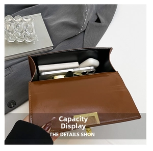 Internal capacity of the brown leather crossbody bag showing phone and accessories