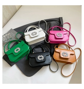 Top view of five colorful mini crossbody bags with decorative crystal buckles on a table