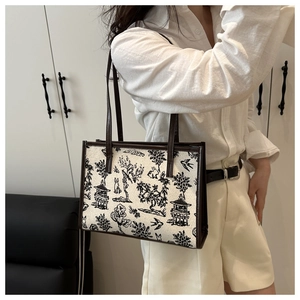 Vista laterale di una borsa tote in tela con stampa paesaggio vintage e spalline in pelle