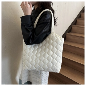 Detail of white quilted tote bag featuring lightweight fabric and cloud-like texture