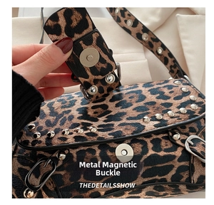 Close-up of leopard print shoulder bag featuring silver rivets and magnetic snap closure